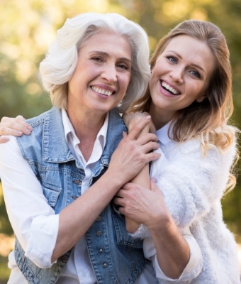 Mother and daughter hugging outdoors