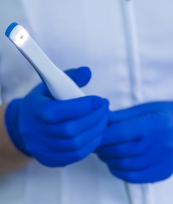 Gloved hands holding an intraoral camera