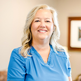 Smiling Claremore dental team member Charlette in blue scrubs