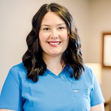 Smiling Claremore dental team member Kelsi in blue scrubs