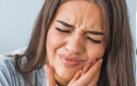 Woman holding her cheeks in pain