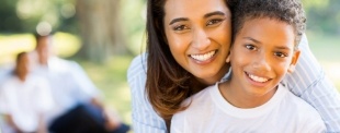 Mother and young son hugging outdoors